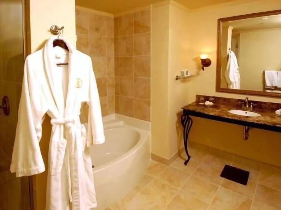 A bathroom with a bathtub, a sink, and a mirror.