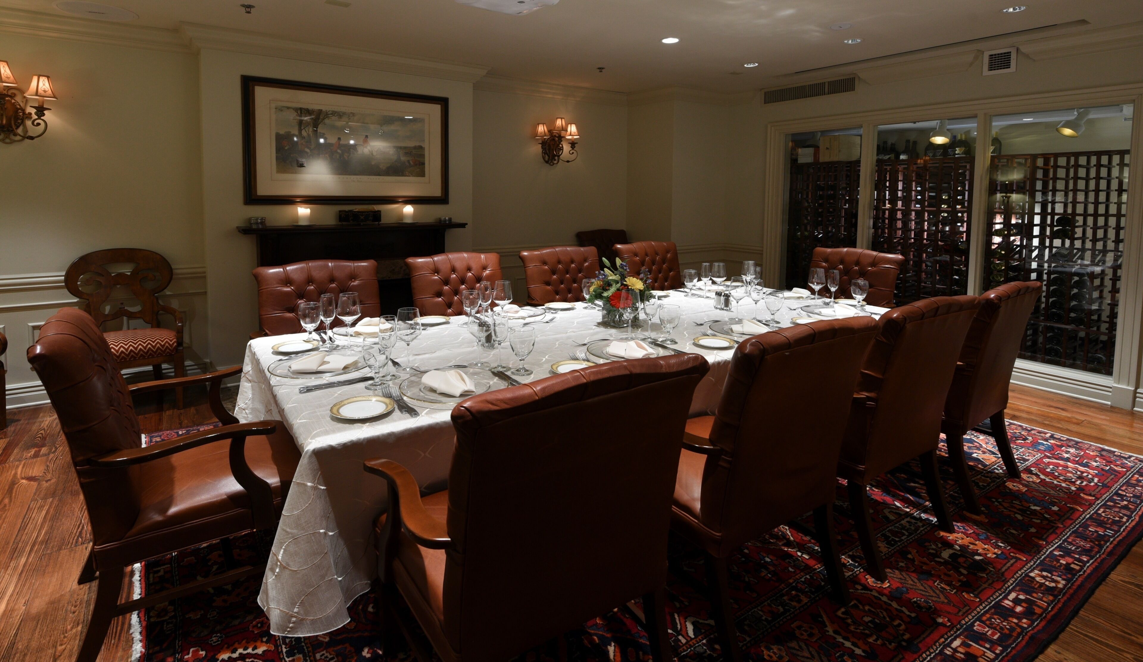 A dining room with a large table set for a meal, surrounded by leather chairs.