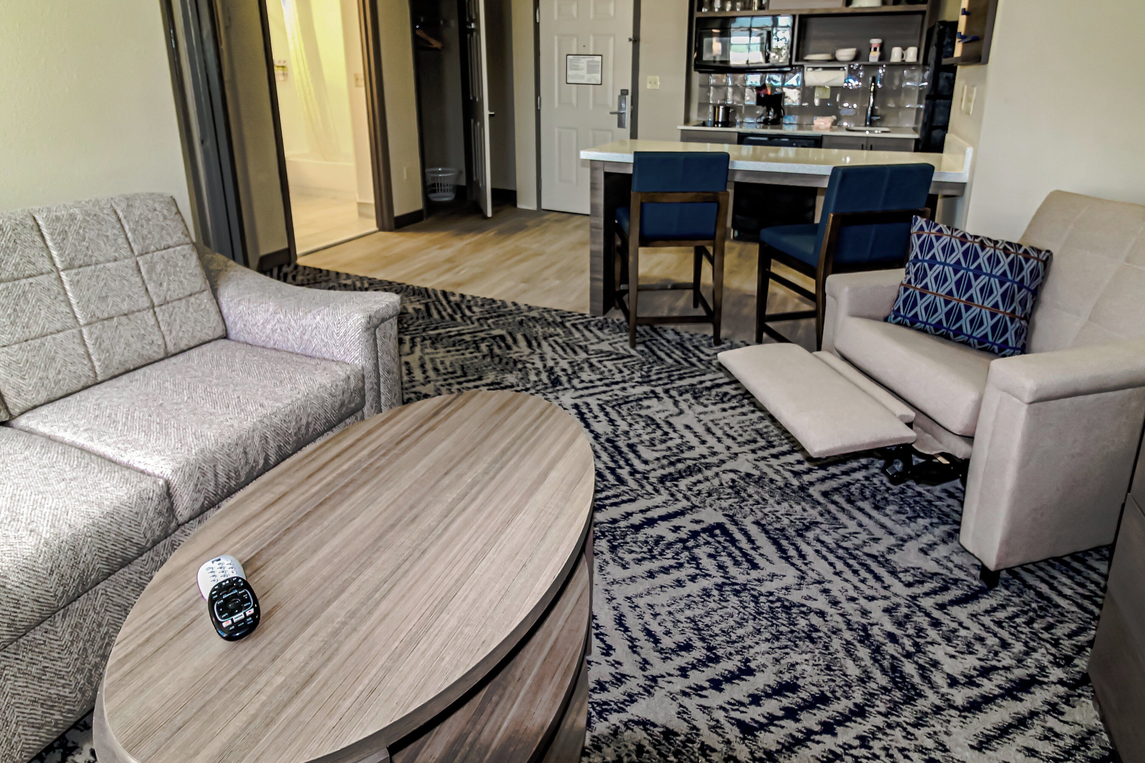 A modern living room with a sofa, a round coffee table, and a patterned rug.