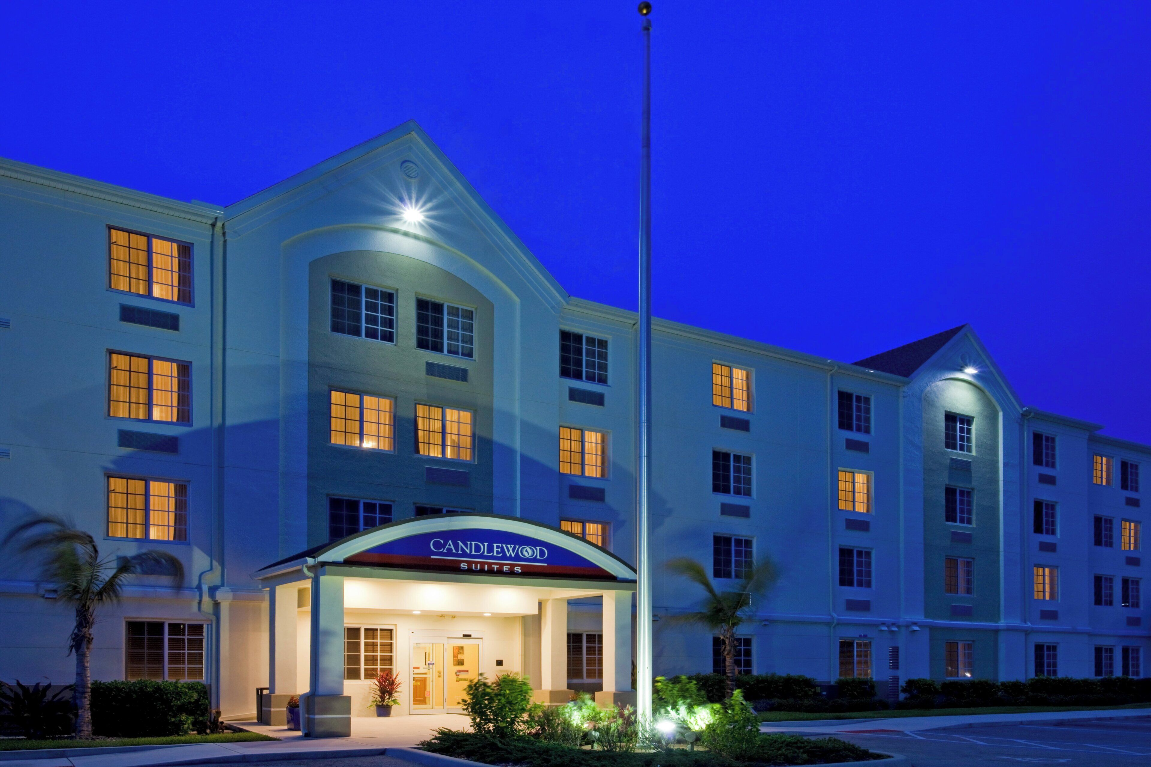A hotel with a prominent entrance, multiple windows, and a flagpole.