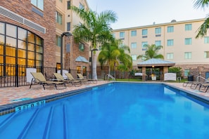 A hotel pool area with lounge chairs and a clear blue pool. - Staybridge Suites McAllen by IHG (McAllen)