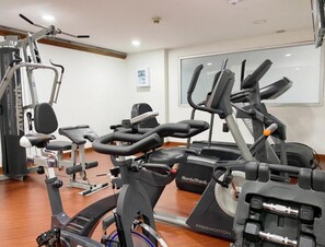A gym with stationary bikes, a weight machine, and a treadmill. - Hotel Bogotá Regency Usaquén (Bogotá)