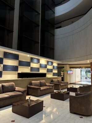 A modern lobby with sofas and coffee tables, a large checkered wall, and a visible entrance. - Hotel Bogotá Regency Usaquén (Bogotá)
