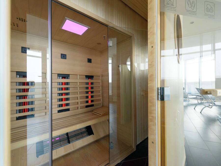 A modern library with wooden shelves and a glass partition.
