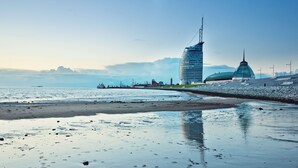 A waterfront with a modern building and a dome structure.