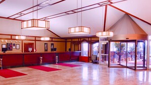 A hotel reception area with a reception desk, a glass door entrance, and a red carpet. - The Green Park Kartepe (Kartepe)