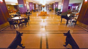 A lobby with a grand piano, multiple dining tables, and two statues of dogs. - The Green Park Kartepe (Kartepe)