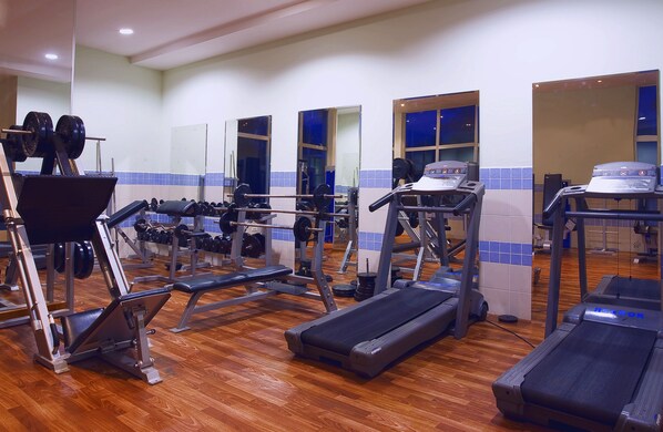 A gym with treadmills, weight machines, and free weights.