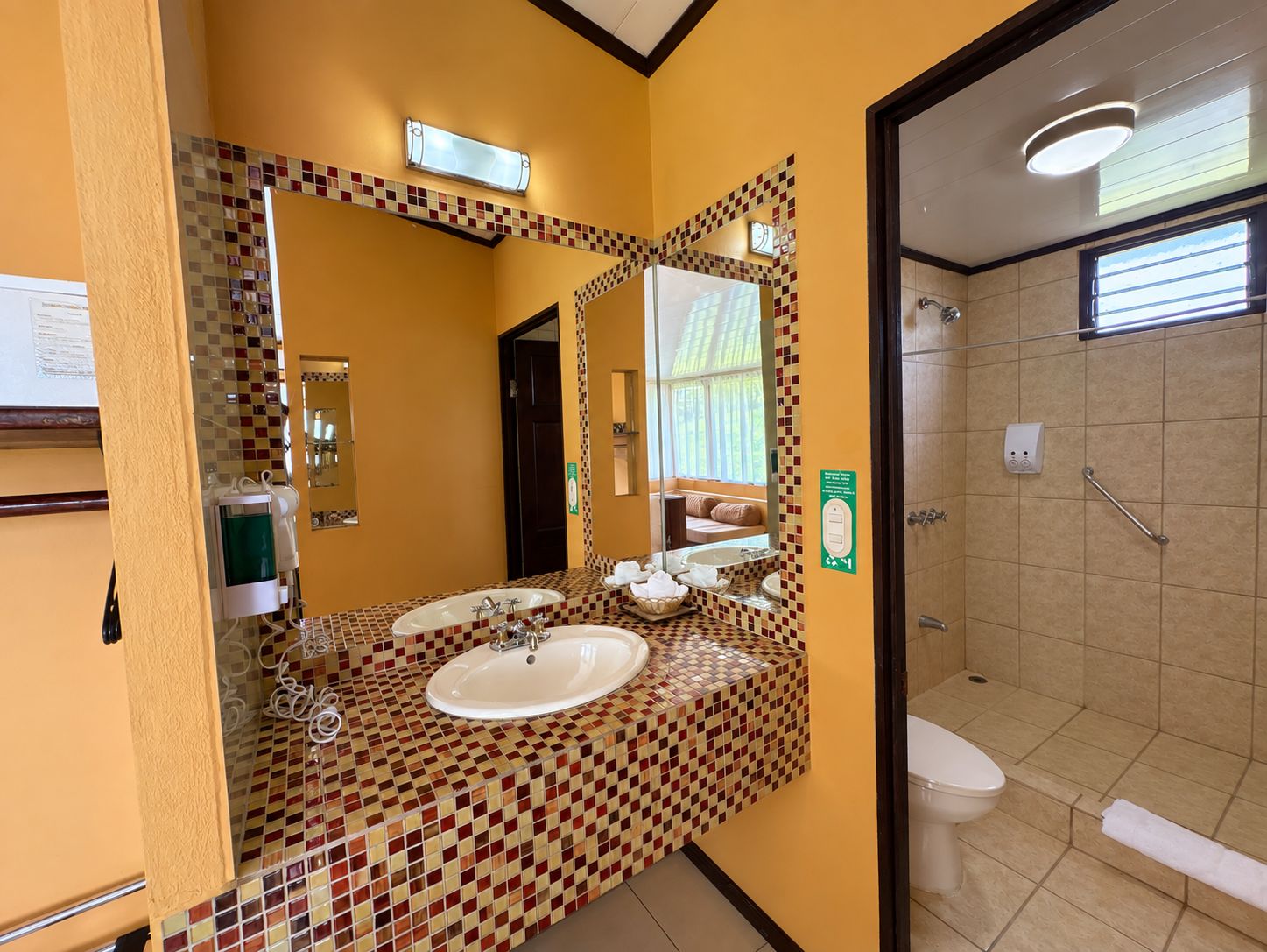A bathroom with a tiled floor, a sink, a mirror, and a toilet.