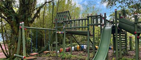 A playground with a slide, climbing structures, and swings.