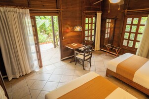 A wooden room with a bed, a desk, and a chair.