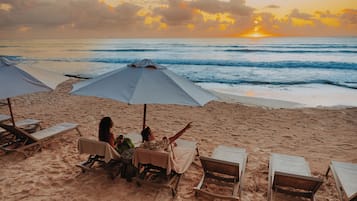 På stranden, hvit sand, strandtelt (inkludert) og solsenger