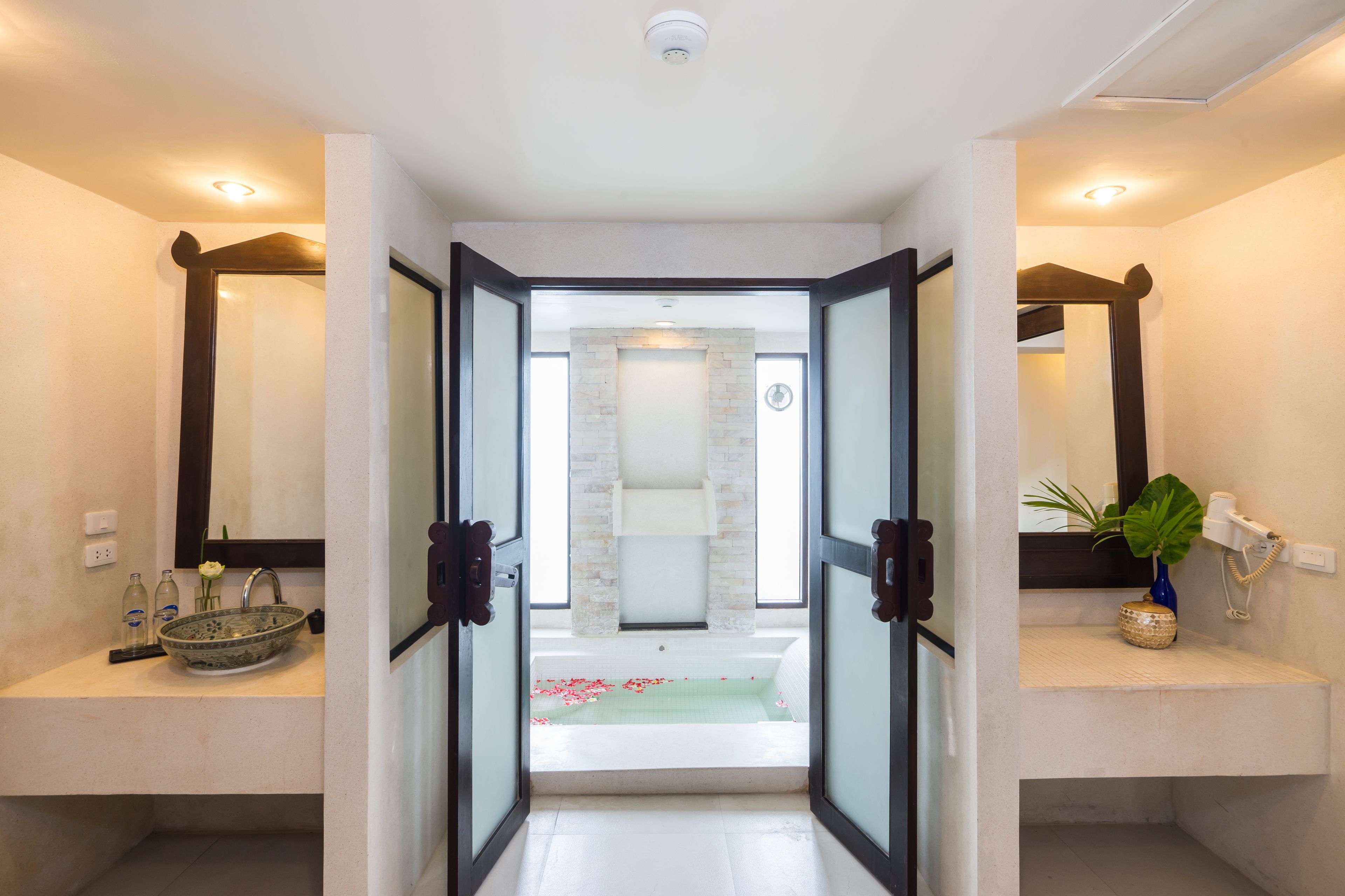 A modern bathroom with a glass-enclosed shower, a large mirror, and a vanity with a bowl sink.