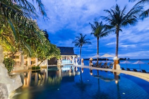 Una piscina al aire libre, sombrillas, tumbonas