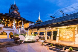 A traditional building with a prominent staircase, a large illuminated sign, and a detailed mural on the facade. - Dara Samui Beach Resort - Adults Only (Koh Samui)