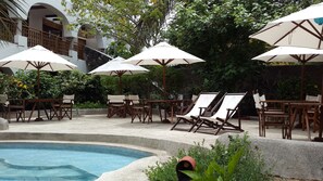 室外游泳池，06:30 至 20:30 开放，池畔遮阳伞，日光浴躺椅