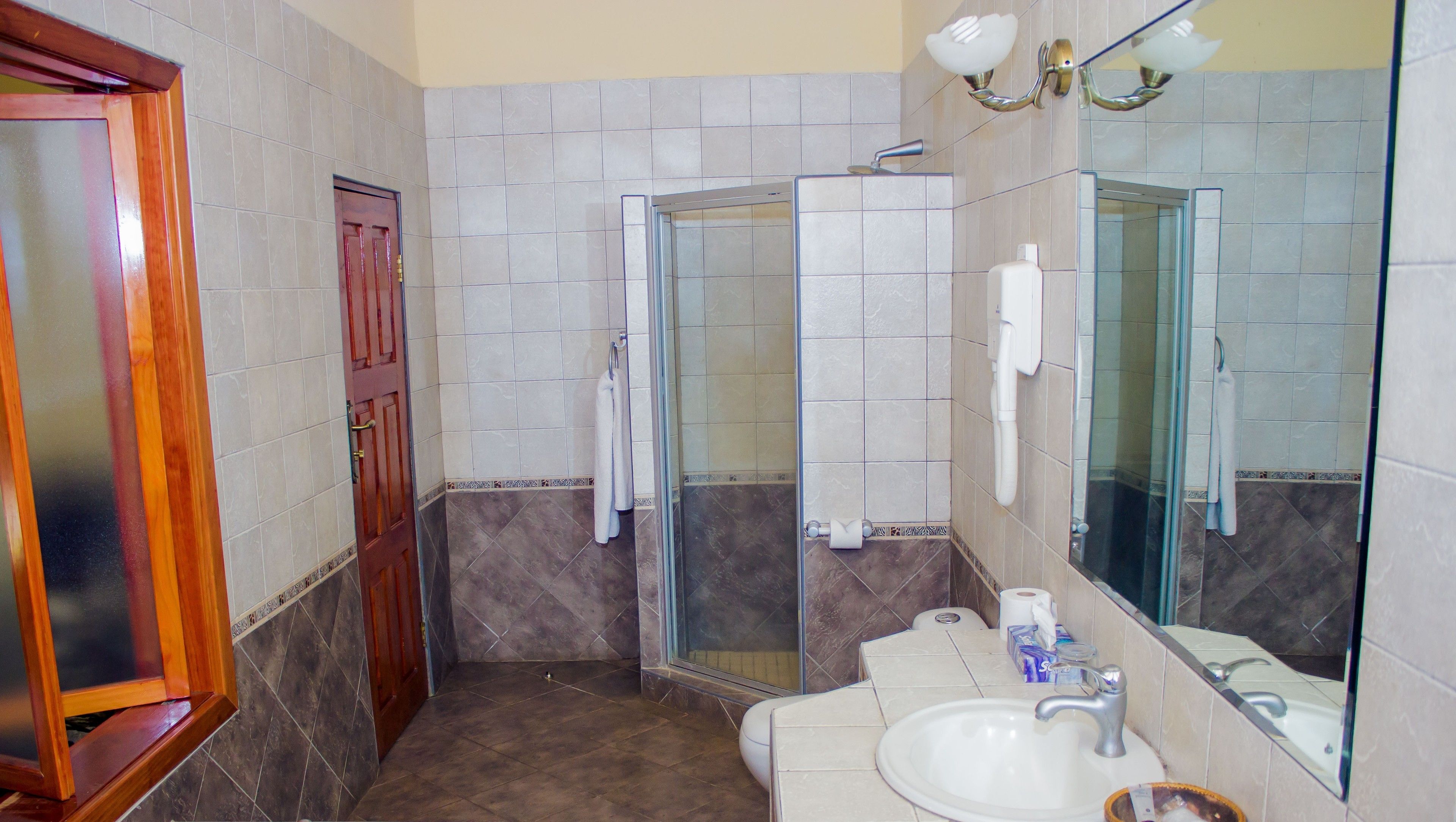 A bathroom with a shower, a sink, and a mirror.
