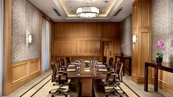 A conference room with a large table, chairs, and a chandelier.
