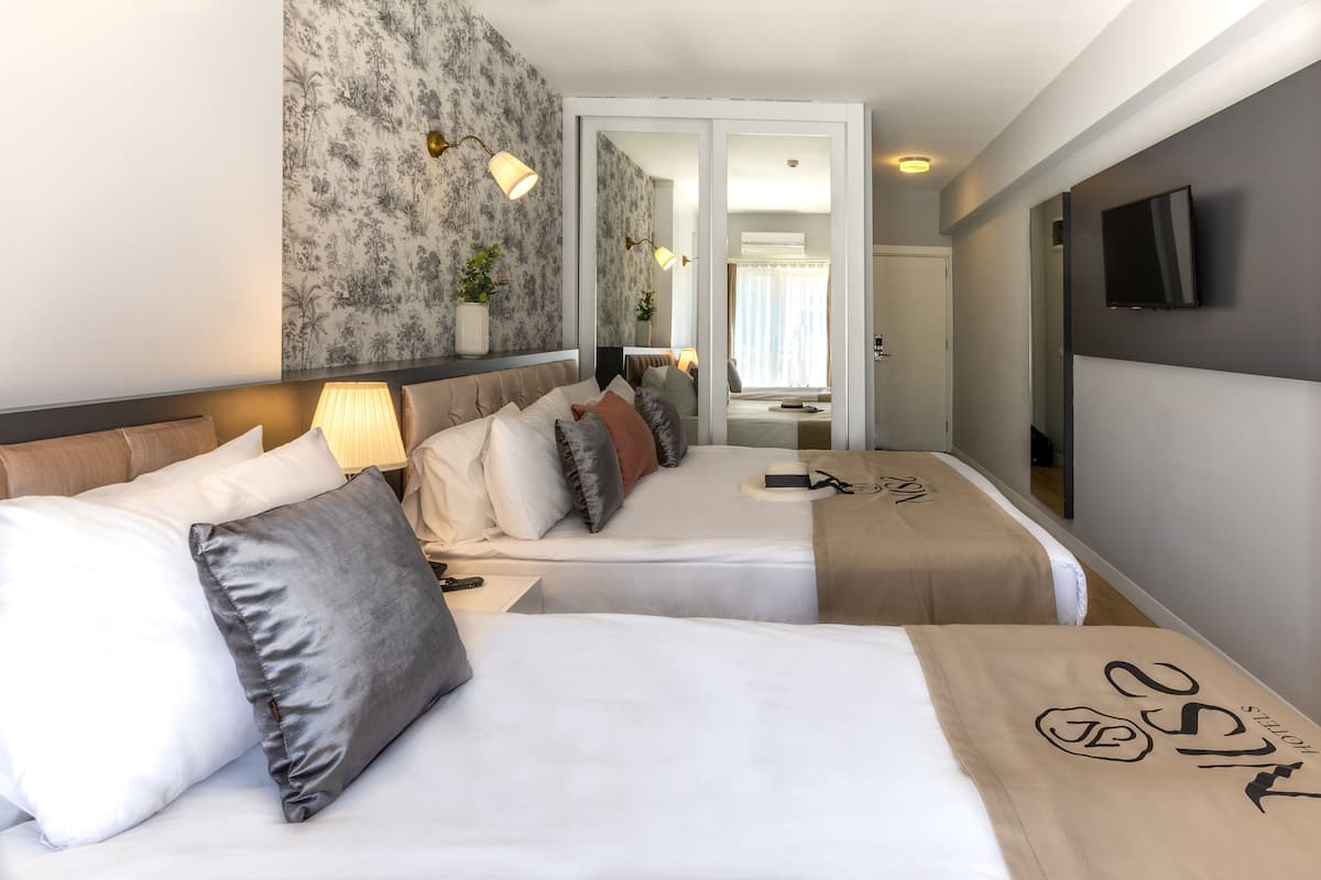 Superior driepersoonskamer | Luxe beddengoed, een minibar, een kluis op de kamer, een bureau