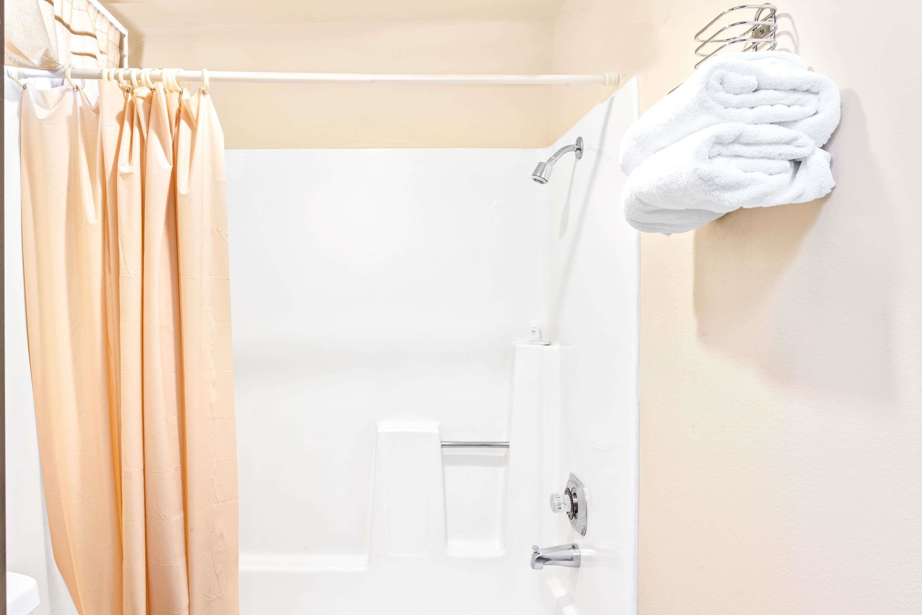 A bathroom with a shower curtain, a towel rack, and a toilet.