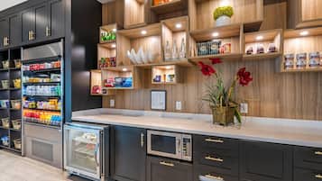 Una cucina moderna con elettrodomestici integrati, scaffali in legno e diversi alimenti.