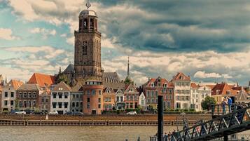 A historic town with a prominent tower, traditional buildings, and a river.