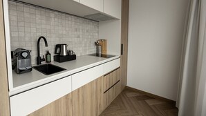 Een moderne keuken met een wit aanrecht, een zwarte spoelbak en houten keukenkastjes.