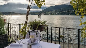 A table set for dining with a view of a lake and mountains.