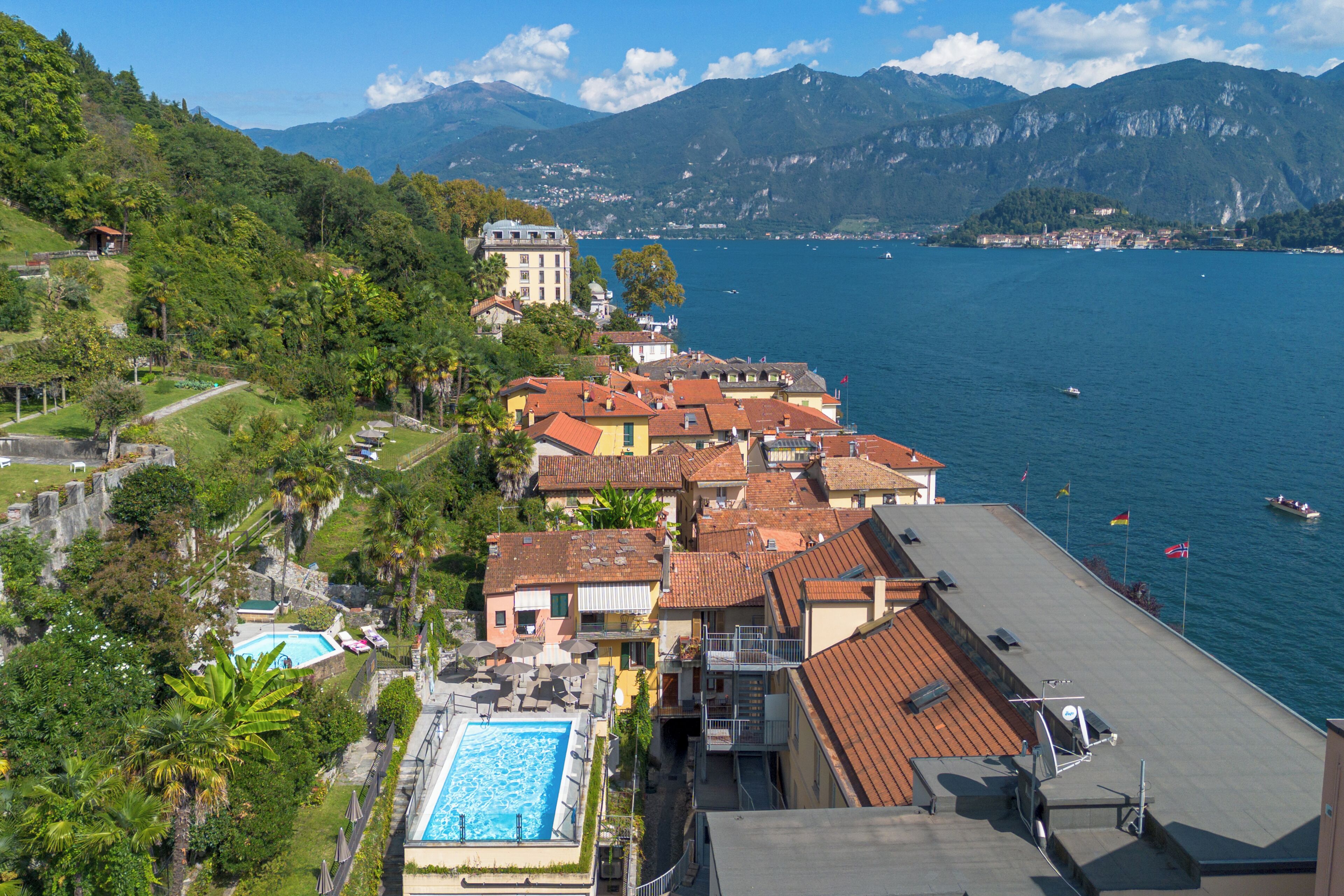 Un hotel sulla costa con piscina, balconi a terrazza e vista sul mare e sulle montagne.