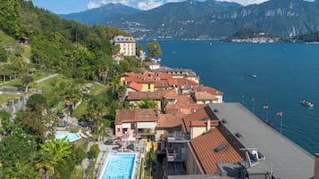 Un hotel sulla costa con piscina, balconi a terrazza e vista sul mare e sulle montagne.