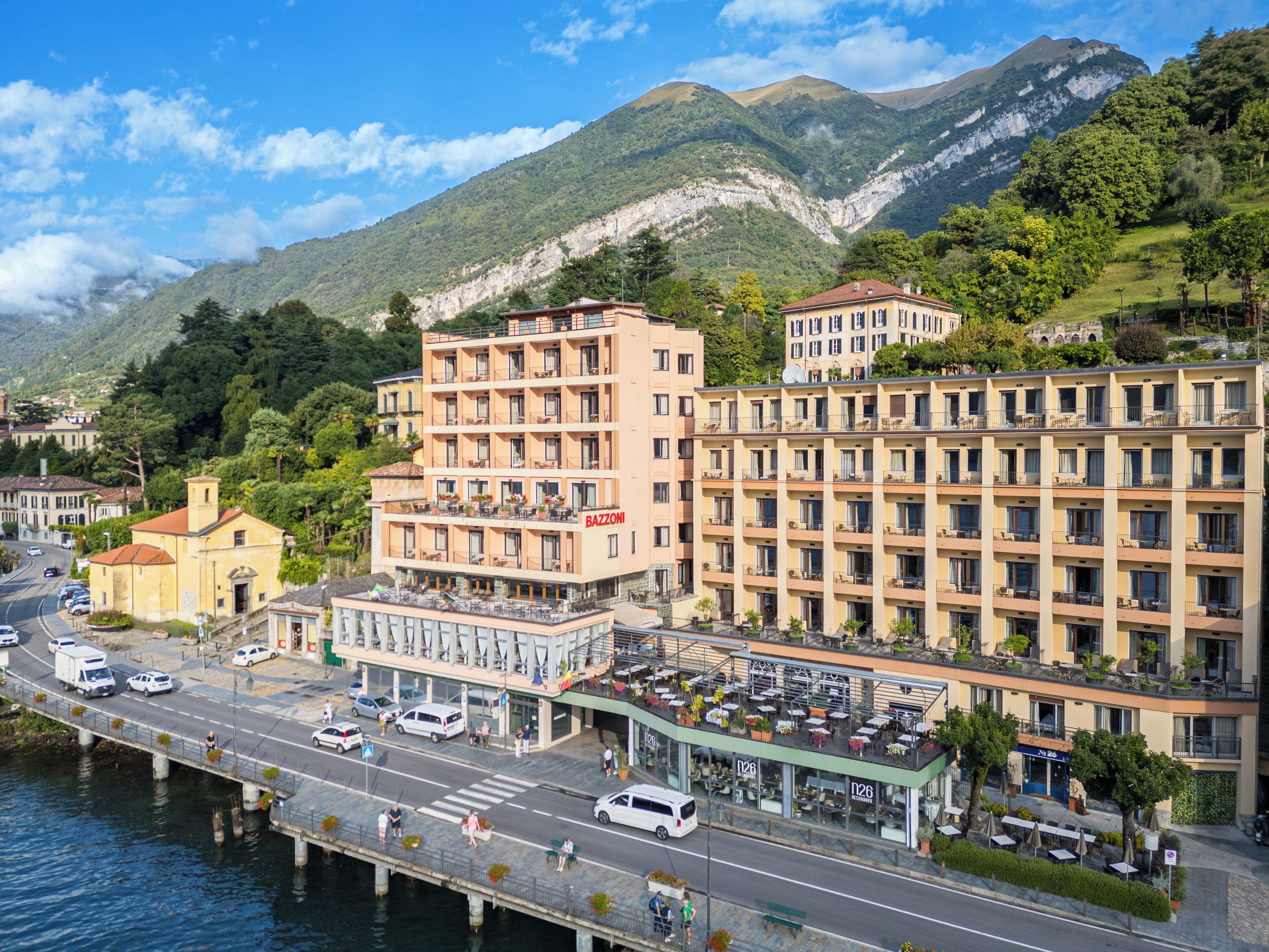 A hotel with multiple floors, outdoor seating, and a view of the surrounding mountains.