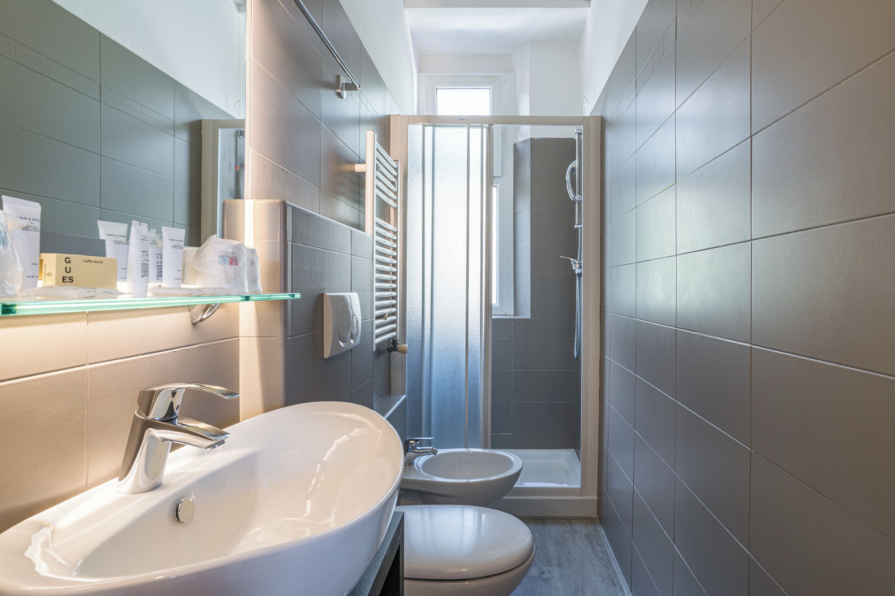 A modern bathroom with a large sink, toilet, and shower.