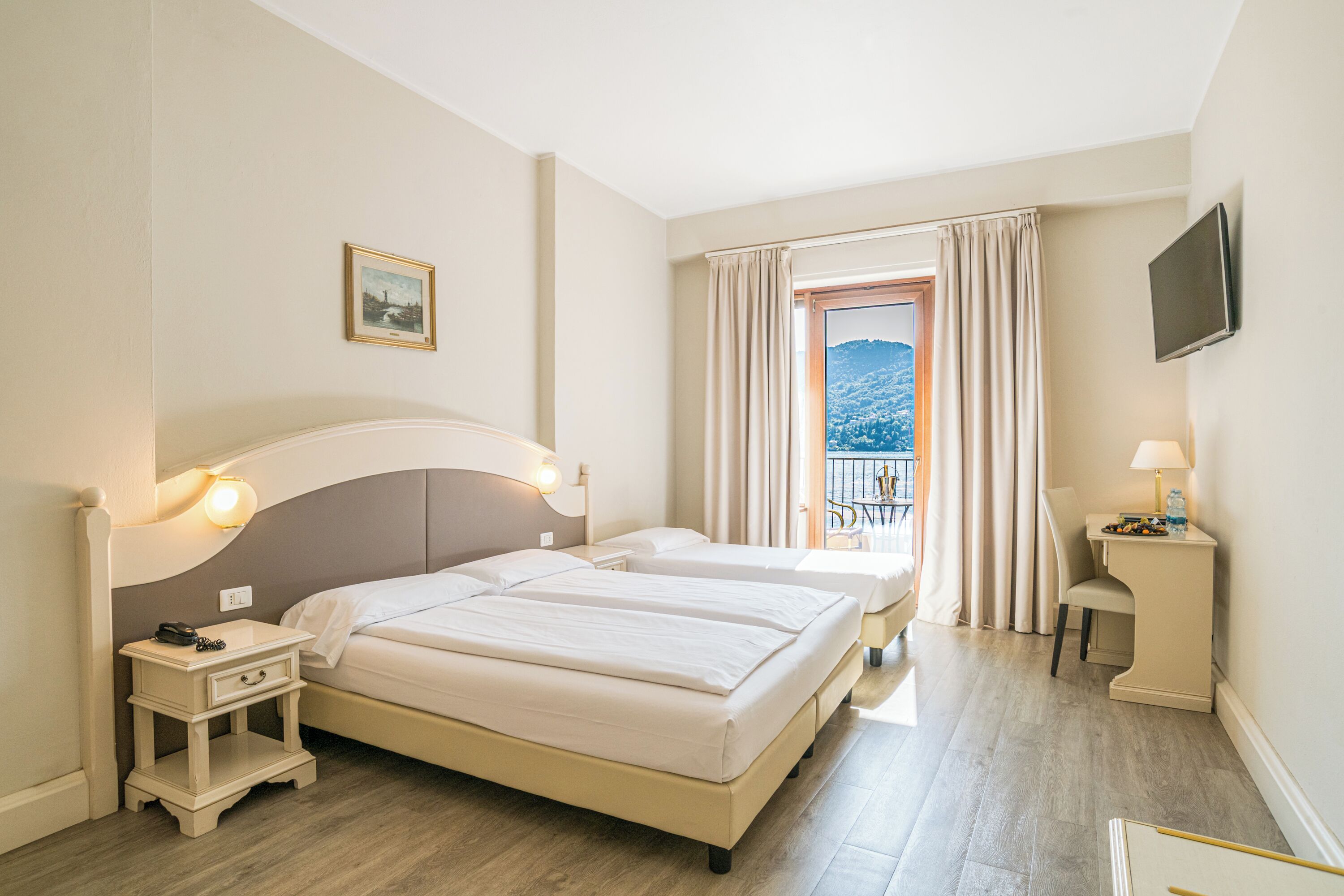 Driepersoonskamer, balkon, uitzicht op meer | Donsdekens, een kluis op de kamer, individueel gedecoreerd, een bureau