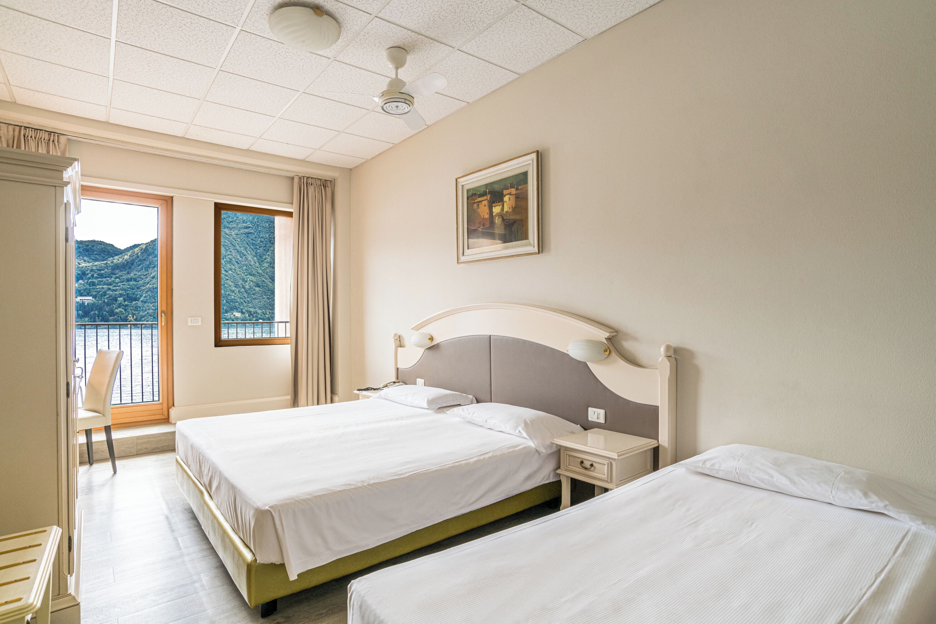 Ein Hotelzimmer mit zwei Betten, einem Schreibtisch und einem Stuhl.