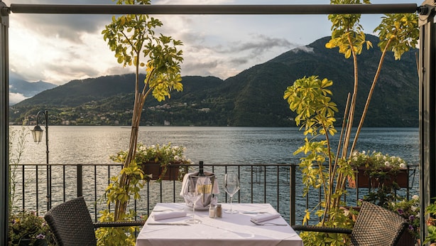 Mesa lista para comer con vista a un lago y montañas.