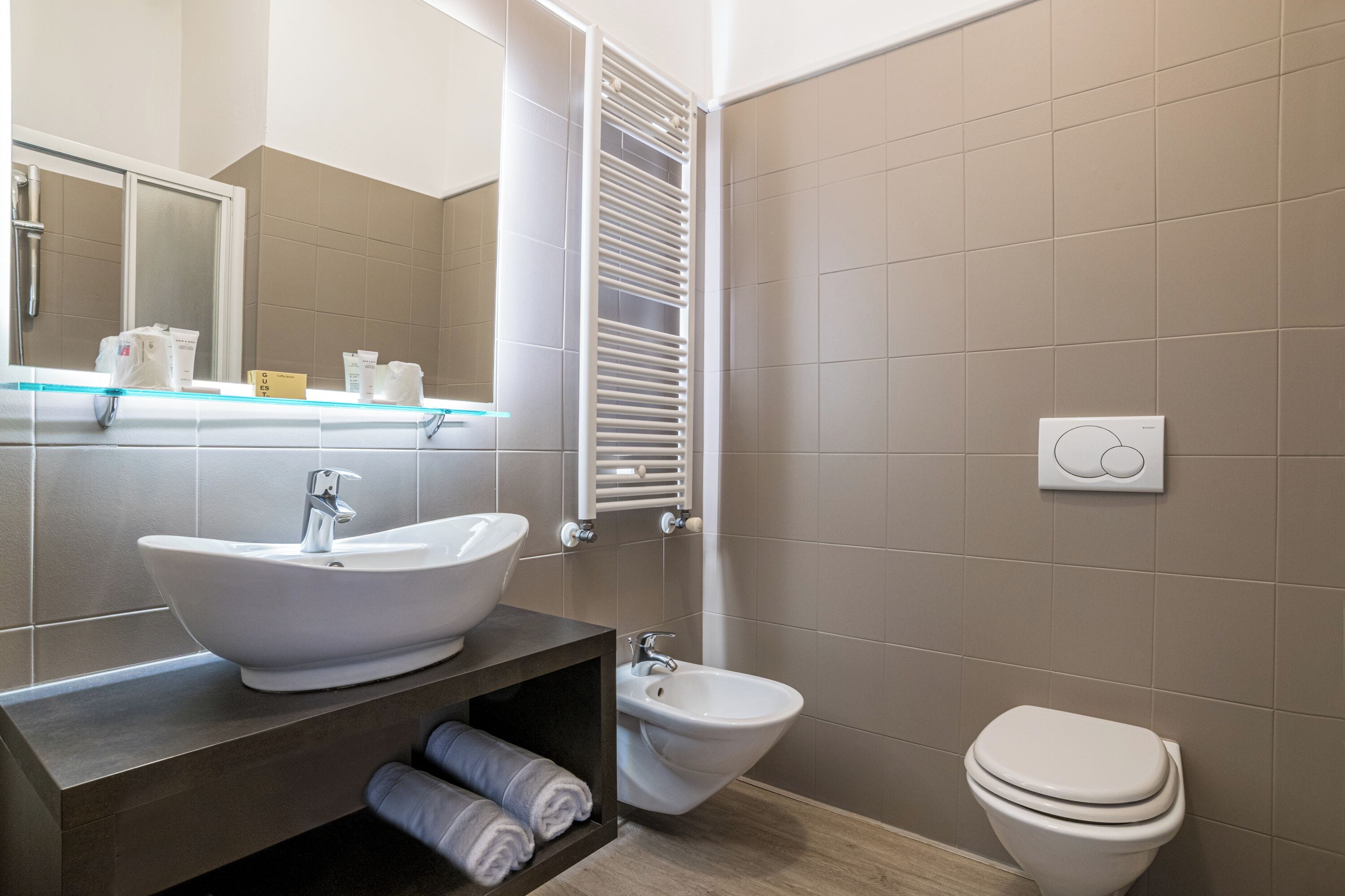 A modern bathroom with a sink, bidet, and toilet.
