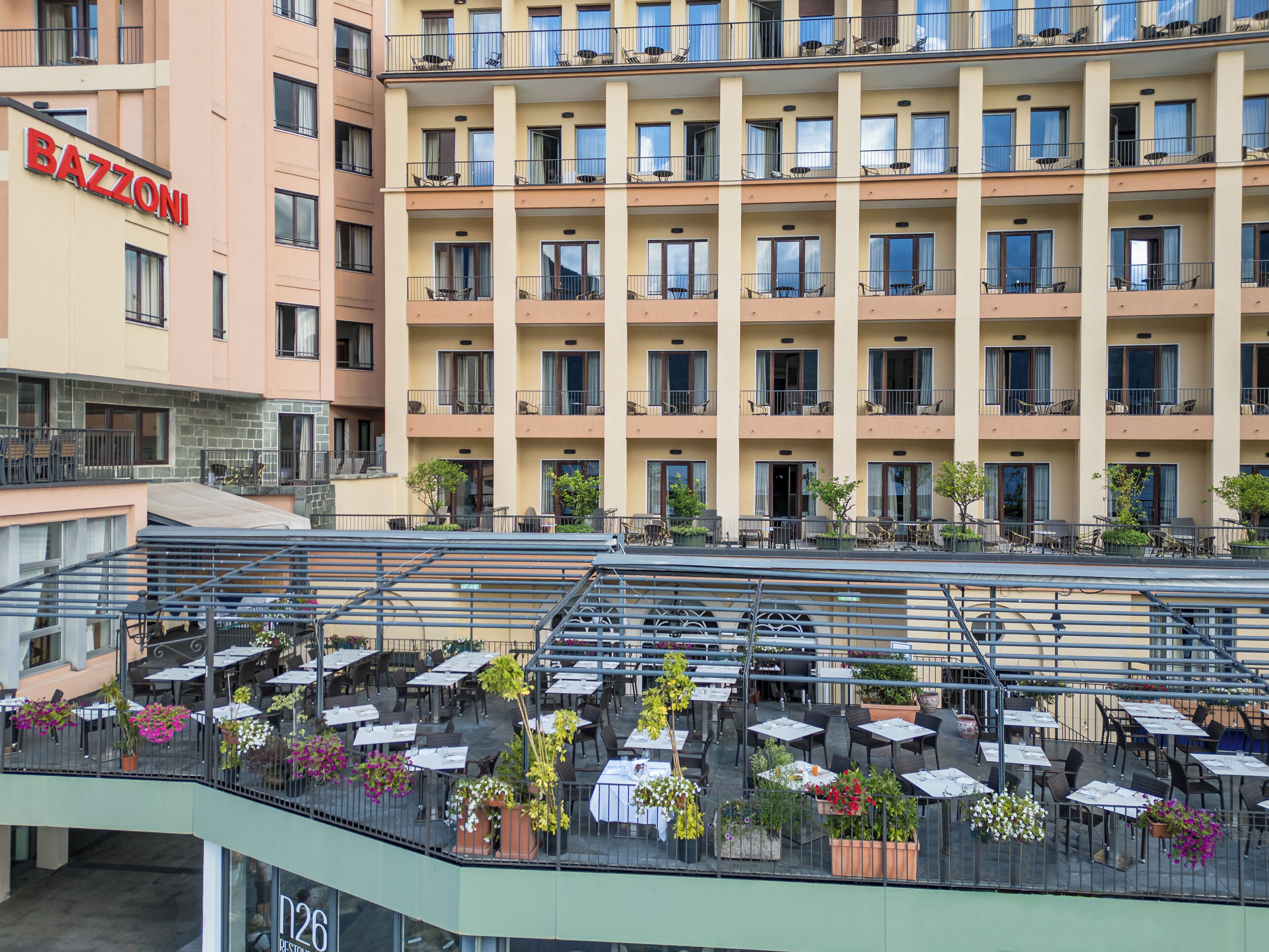A multi-story hotel with outdoor seating and balconies.