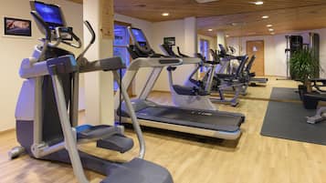 A gym with treadmills, stationary bikes, and a weight machine.