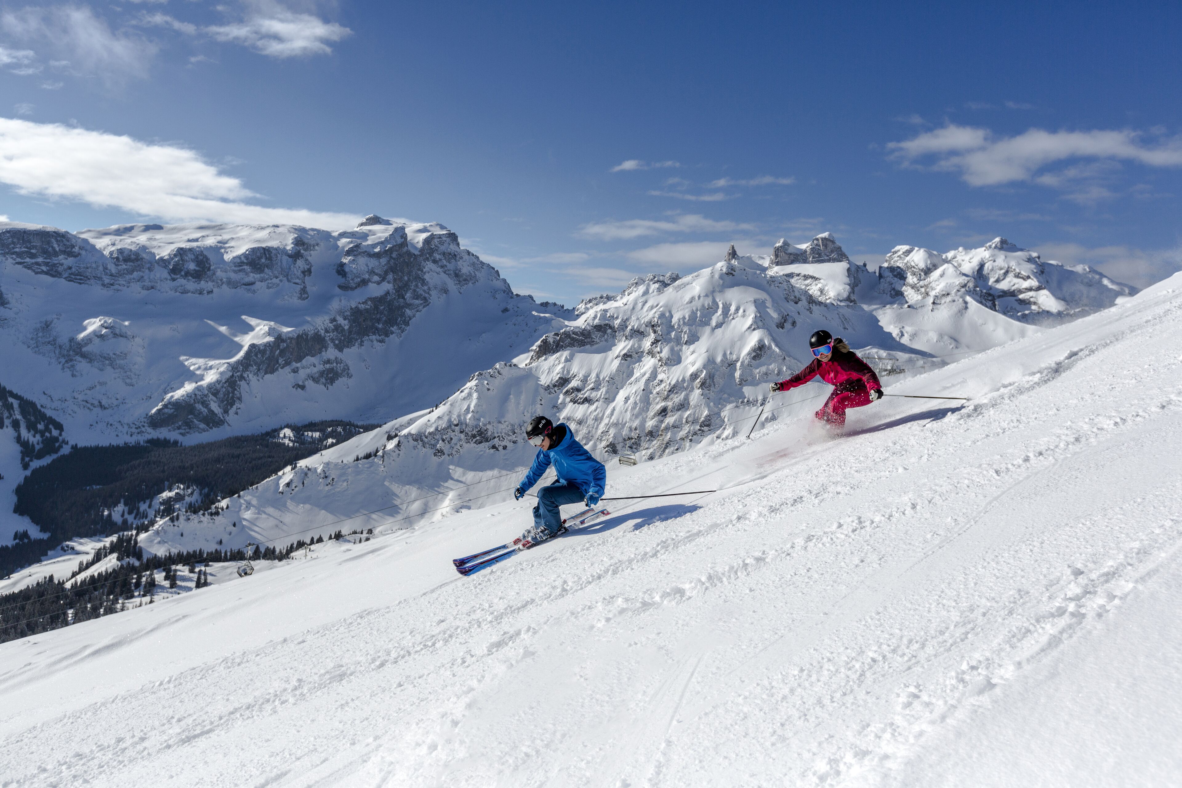 Een besneeuwde helling met skiërs.