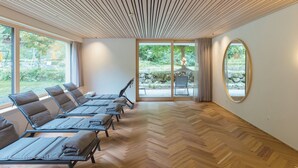 A room with a wooden herringbone floor, large windows, and a view of the outdoors. - Hotel Krone in Au (Au)