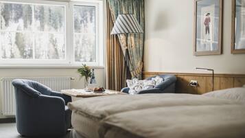 Un dormitorio con un ventanal grande, una lámpara, una silla y una cama.