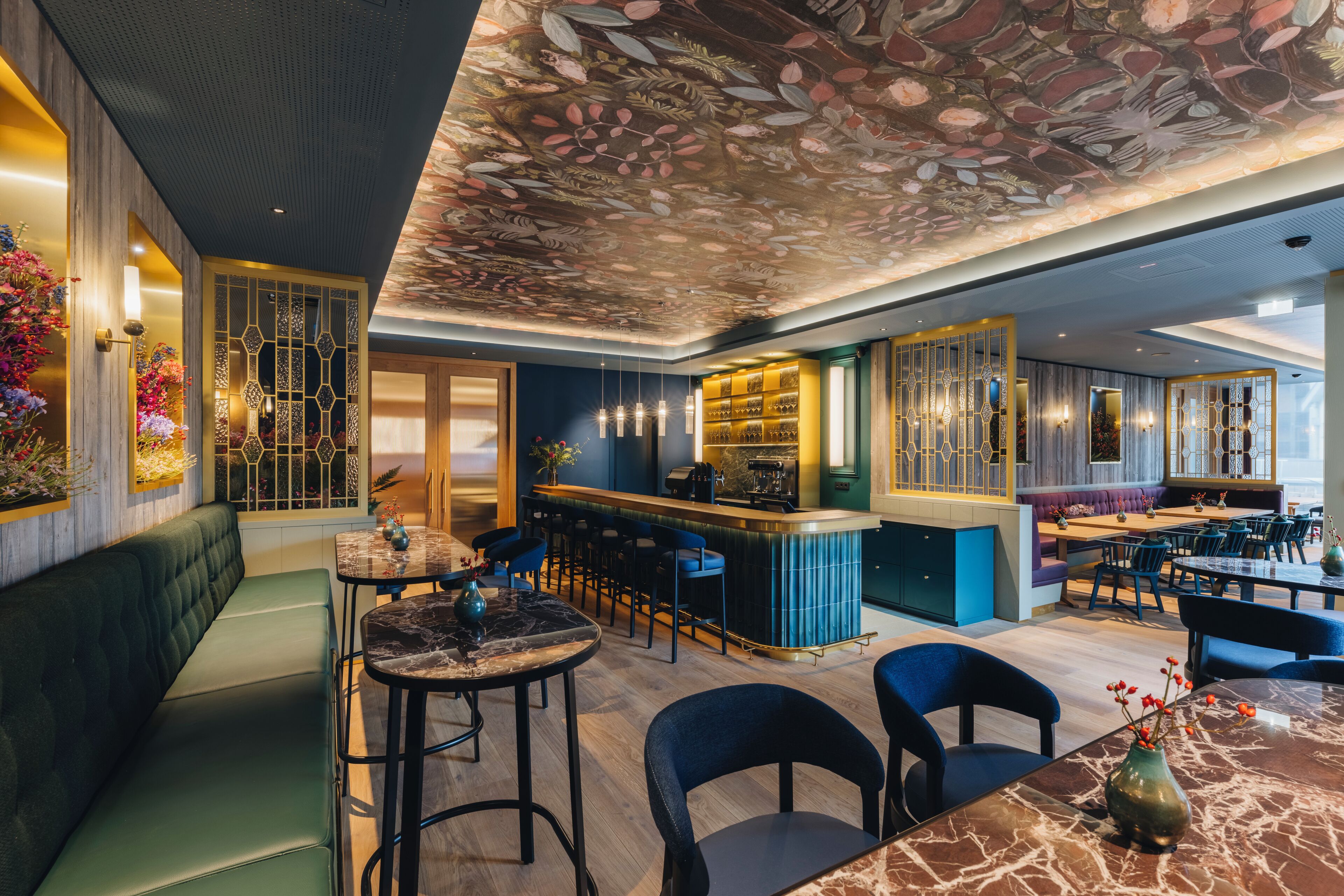 Interior moderno de restaurante com área de bar, disposição de assentos e decoração no teto.