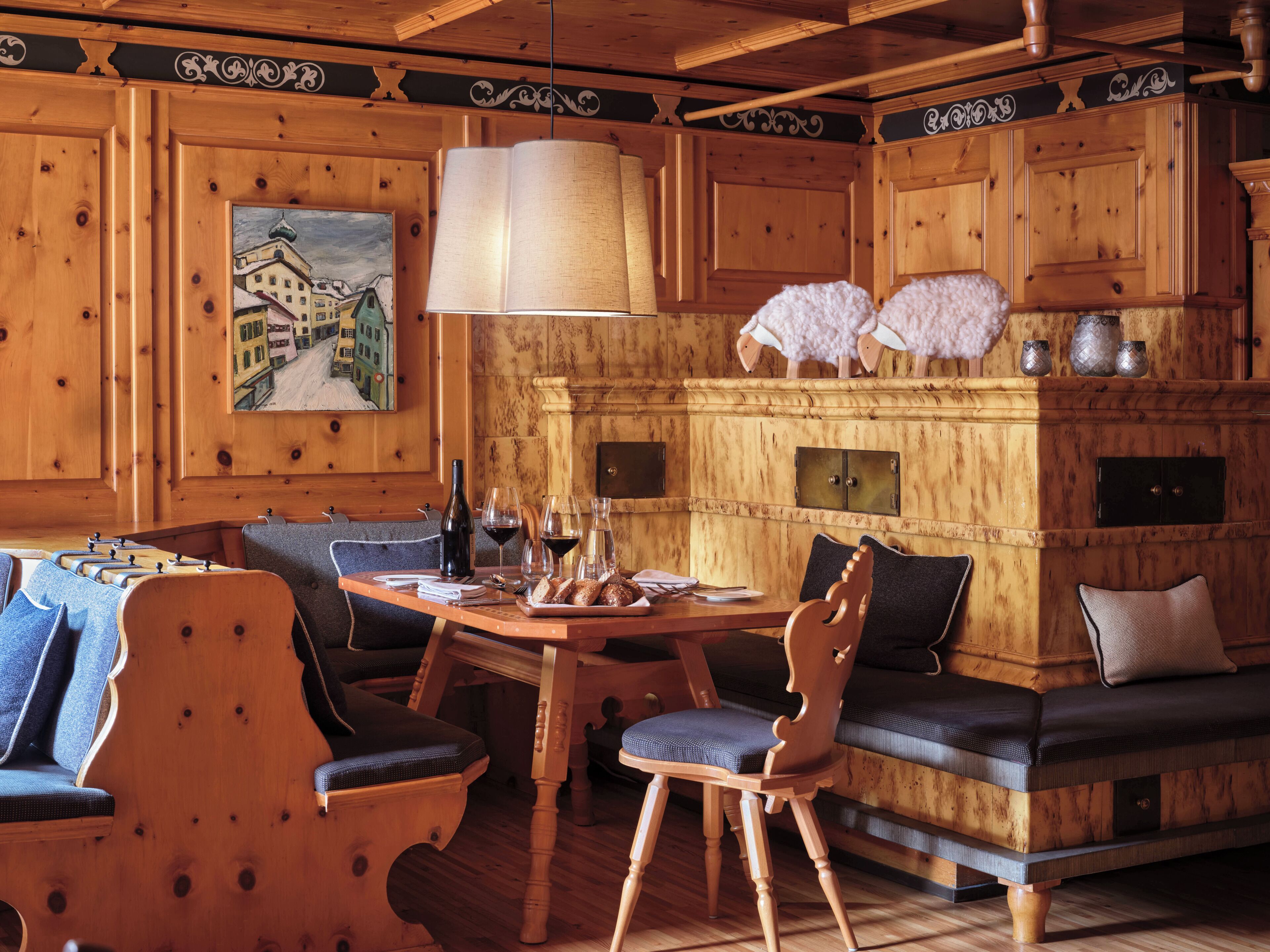 A wooden interior with a dining table, chairs, a sofa, and a fireplace.