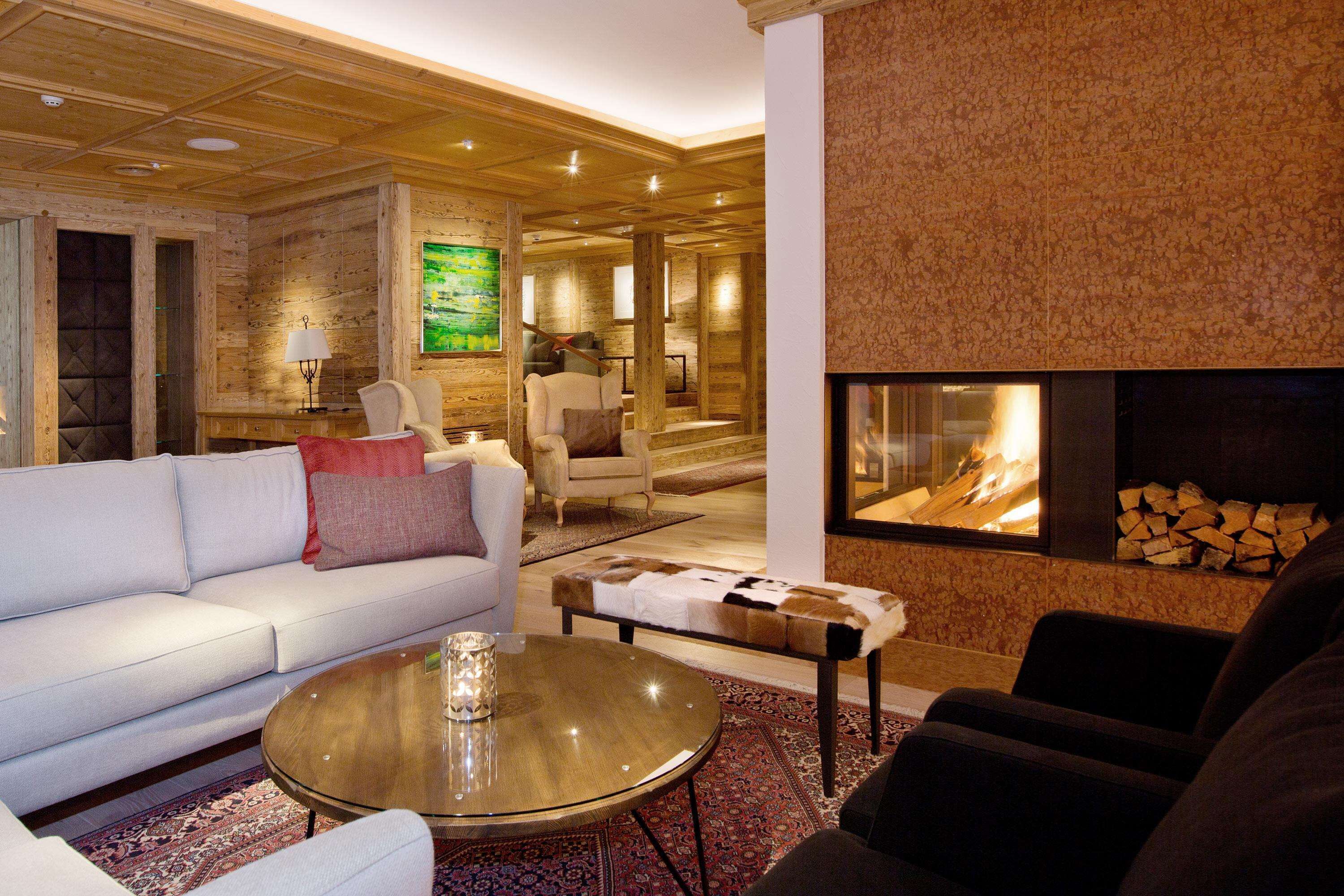 Una sala de estar moderna con chimenea, un sofá, una mesa de centro y un tapete estampado.