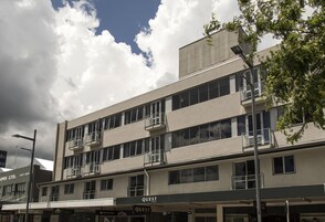 Un edificio de varios pisos con balcones y ventanas amplias.