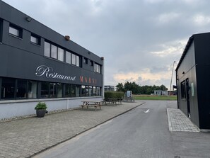 Un restaurant appelé « Restaurant Marni », doté d’une terrasse et d’une allée pavée.