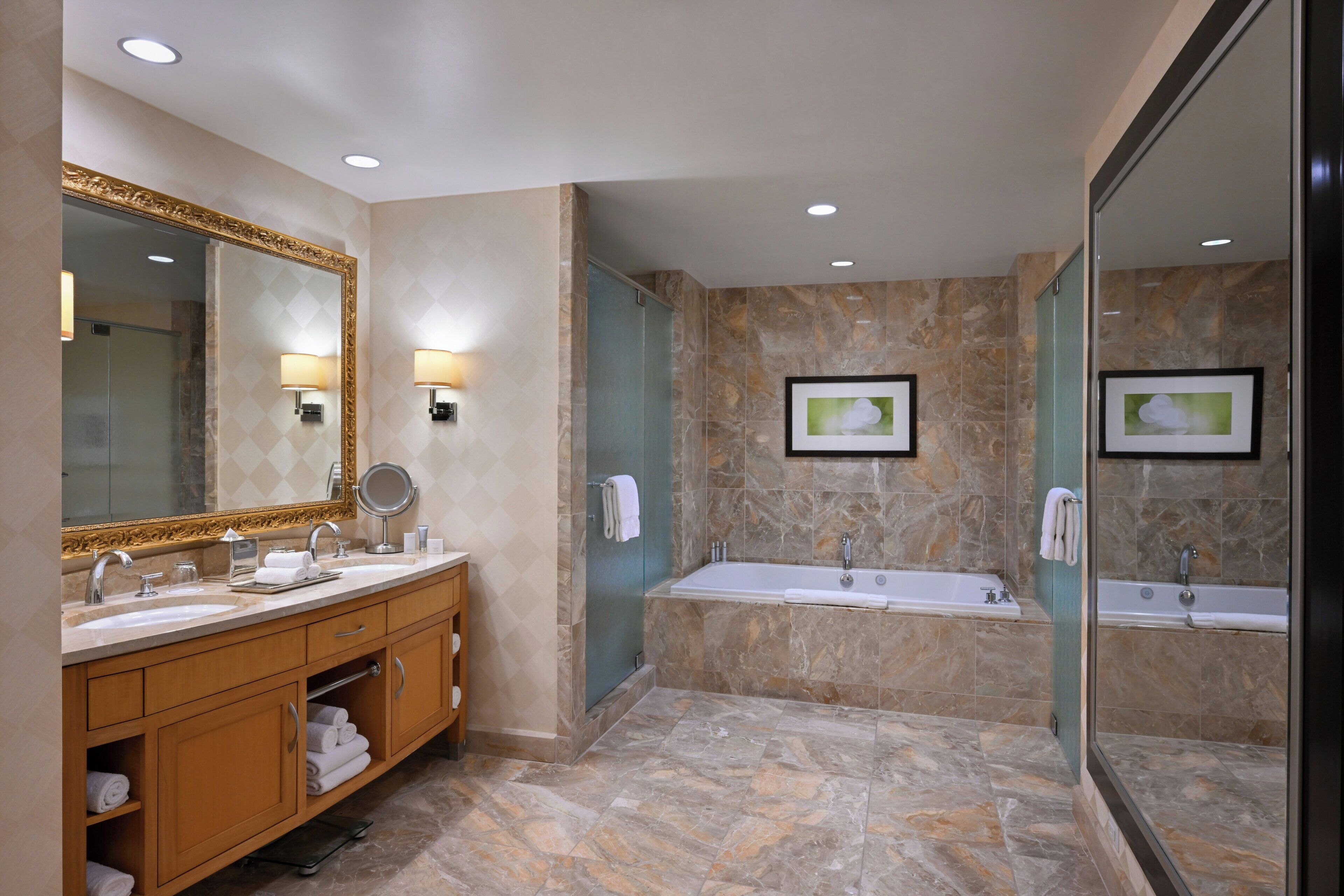 Une salle de bain moderne avec un meuble-lavabo, un grand miroir, une baignoire et un espace douche.