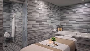 A modern bathroom with a large bathtub, a shower area, and a bed with a towel and a small plant on a tray.