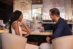 Eine Bar mit Theke, Sitzgelegenheiten und einer dekorativen Wand.
