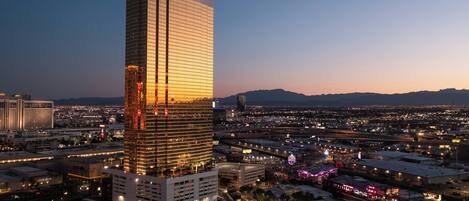 A high-rise building with a prominent 'TRUMP' sign, surrounded by a cityscape with visible roads and distant mountains.